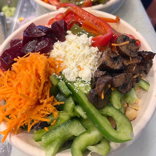 A vibrant Kalamaki Greek salad bowl with beets, carrots, feta, mushrooms, and bell peppers.