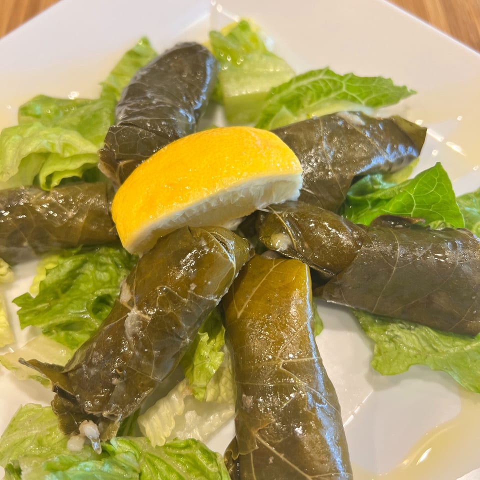 Kalamaki's Greek dolmades, grape leaves stuffed with rice, served on lettuce with a lemon wedge.